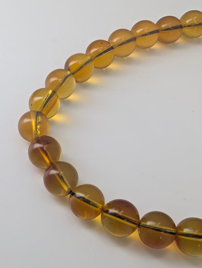Closeup of 6mm Mexican blue amber beads showing honey cognac colour