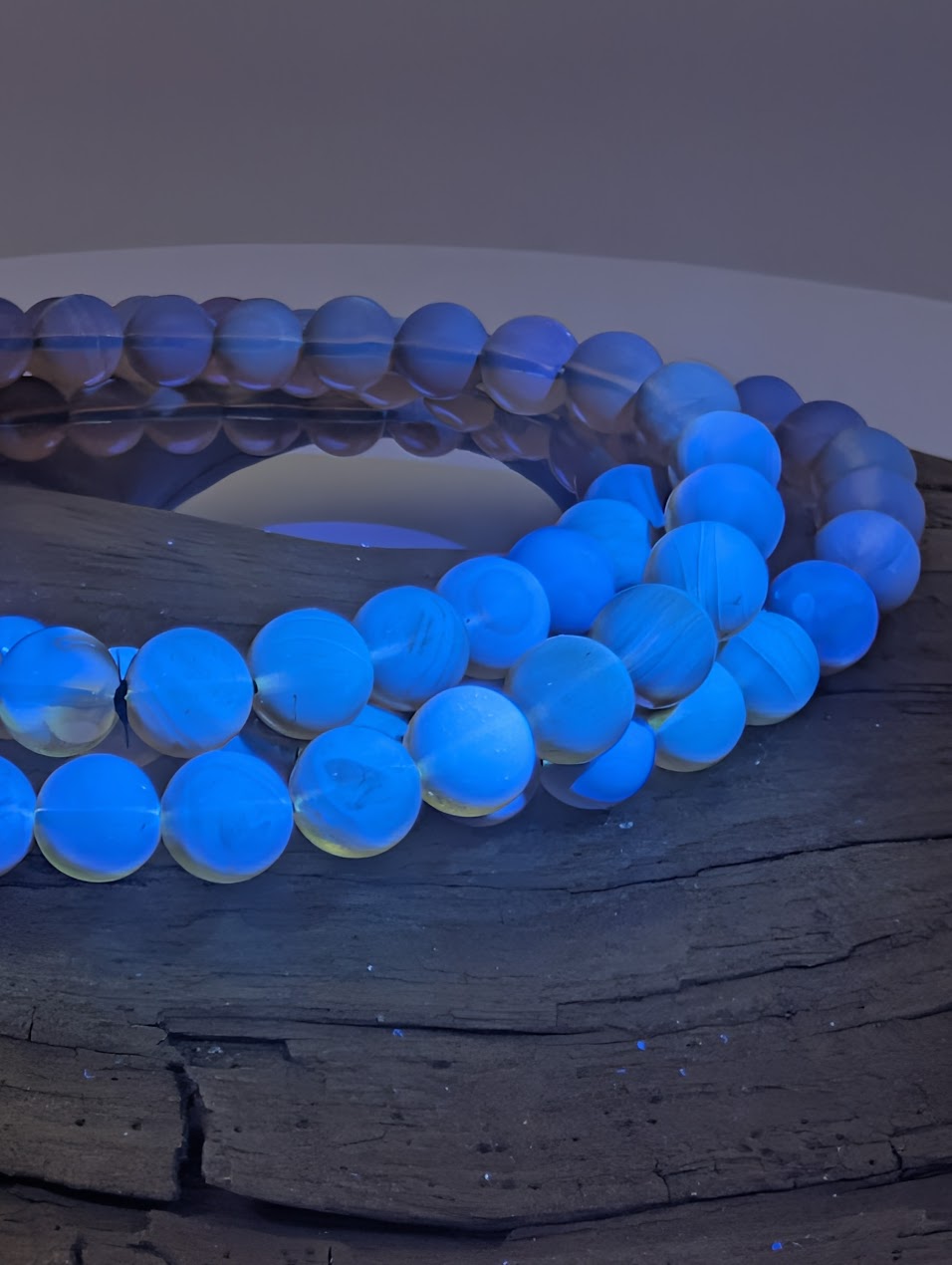 Mexican blue amber bracelet glowing bright blue with halo under UV light
