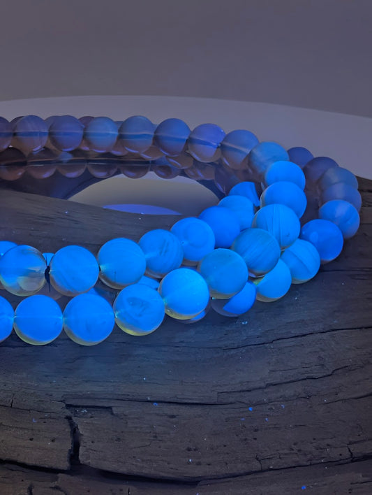 Mexican blue amber bracelet glowing bright blue with halo under UV light