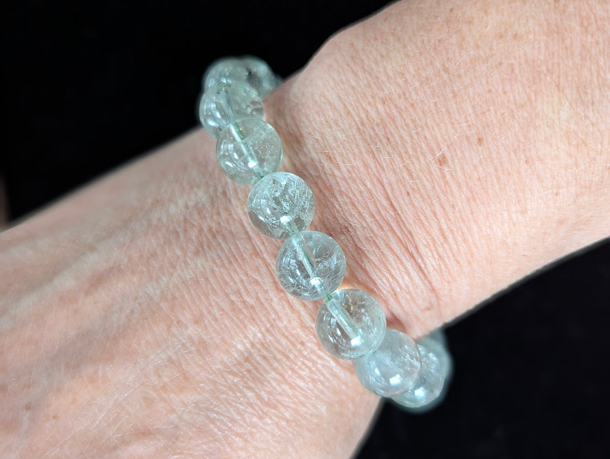 11mm Green Amethyst (Prasiolite) Bracelet shown worn on a wrist, illustrating scale and transparency.
