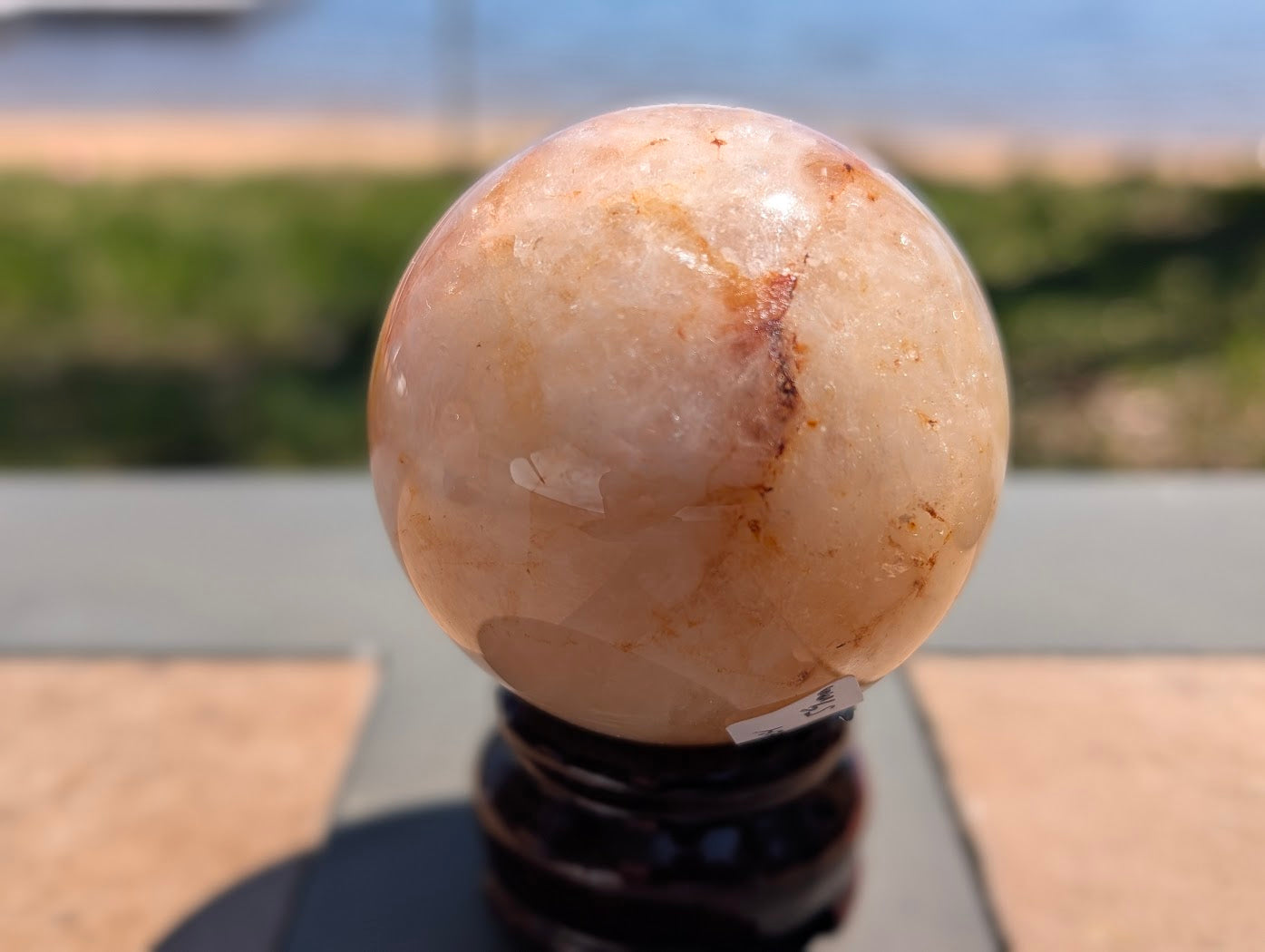 Close-up of Golden Healer quartz sphere GHS-04 highlighting high-contrast colour blocking and dense iron inclusions.