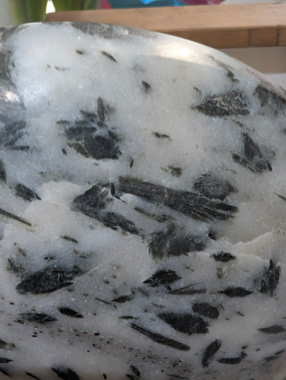 Detailed macro view of forest-green actinolite "hair" suspended within a translucent milky quartz host.