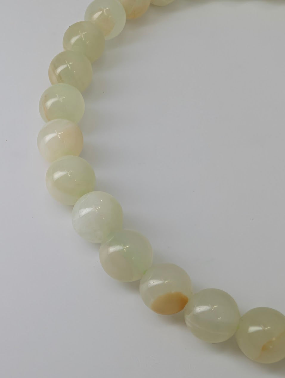Detailed view of natural serpentine beads with soft celadon tones