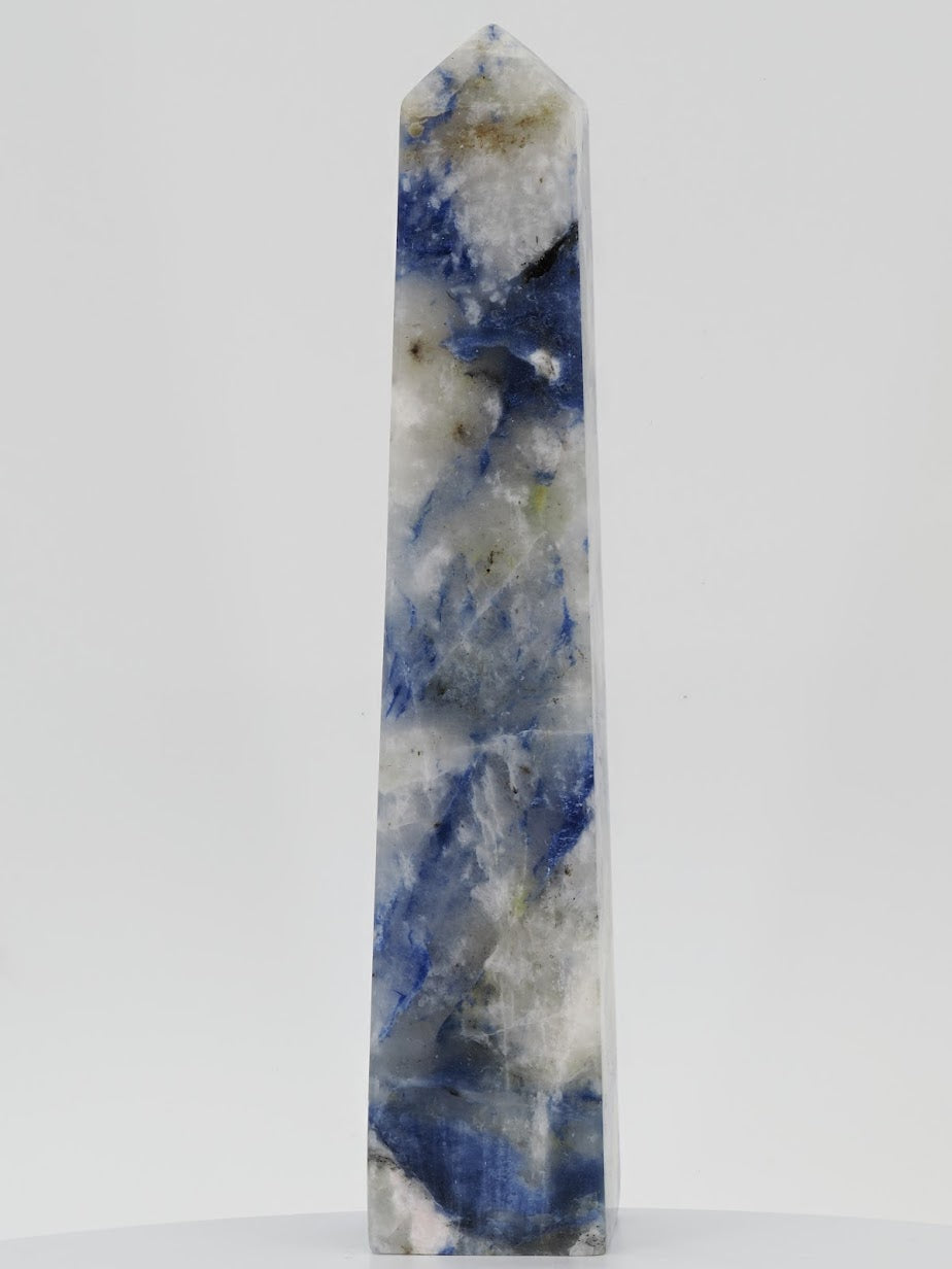 A 4.25-inch Afghanite tower from Afghanistan weighing 240g with a blue identification tag, showing blue and white patterns.