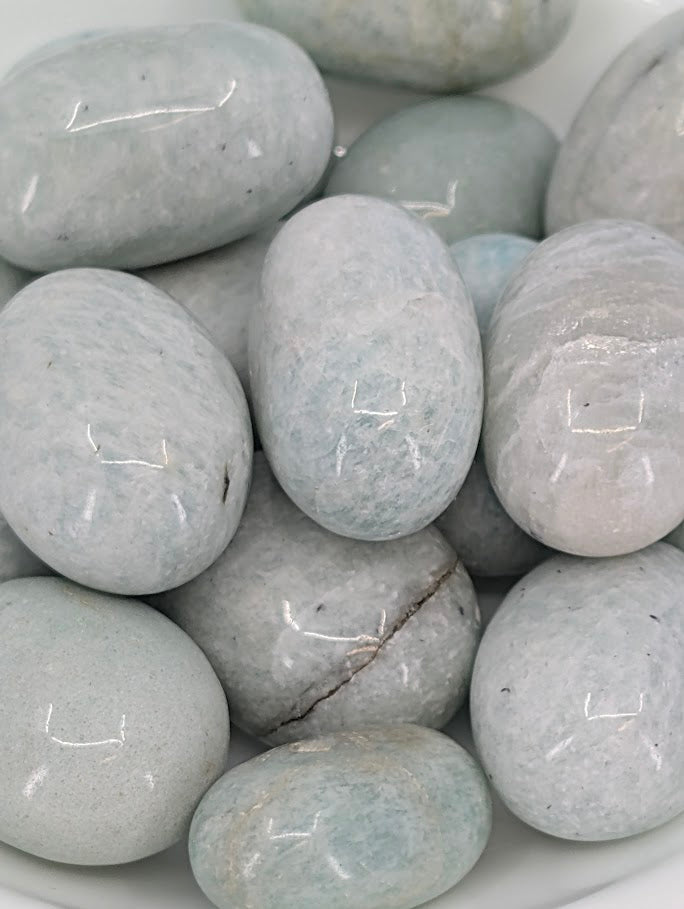 Close-up of Amazonite tumbled stones showing pale aqua color and feldspar shimmer