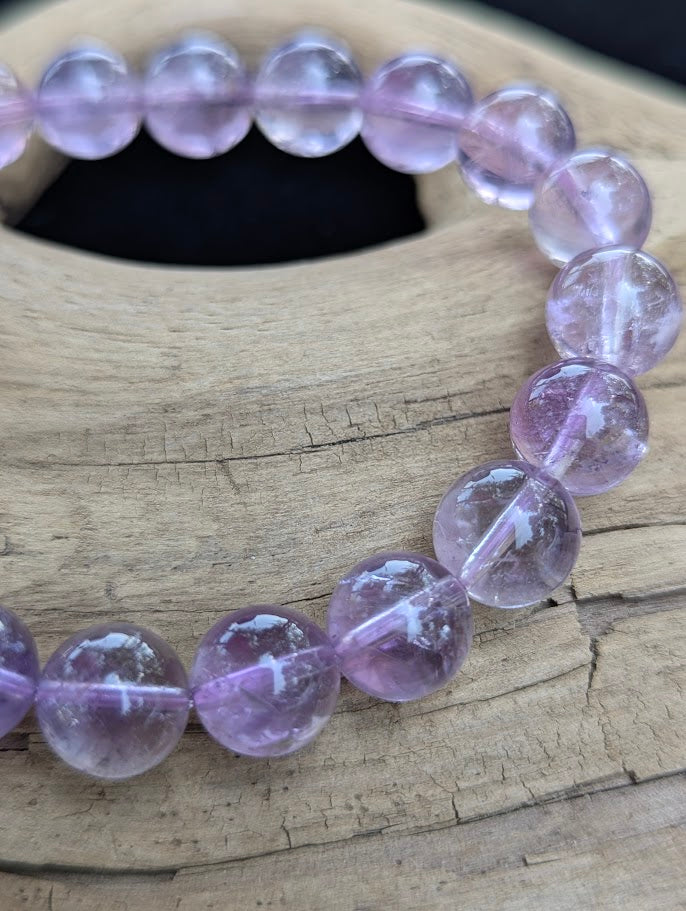 Macro detail of 10mm High Quality Brazilian Amethyst beads displaying high translucency and clear cord construction.