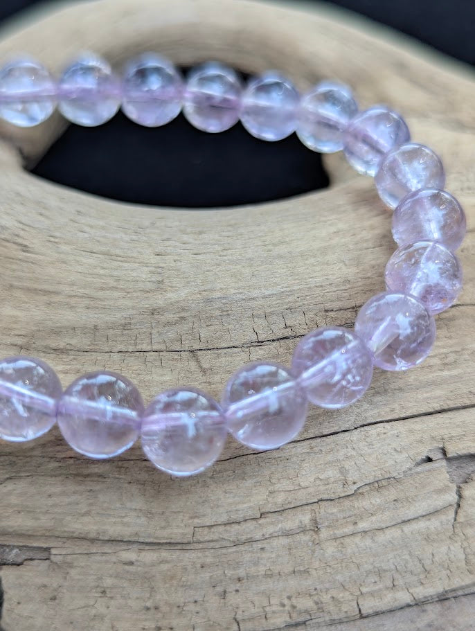 Macro shot of 7mm High Quality Brazilian Amethyst beads highlighting delicate lavender colouration and clear internal structure.
