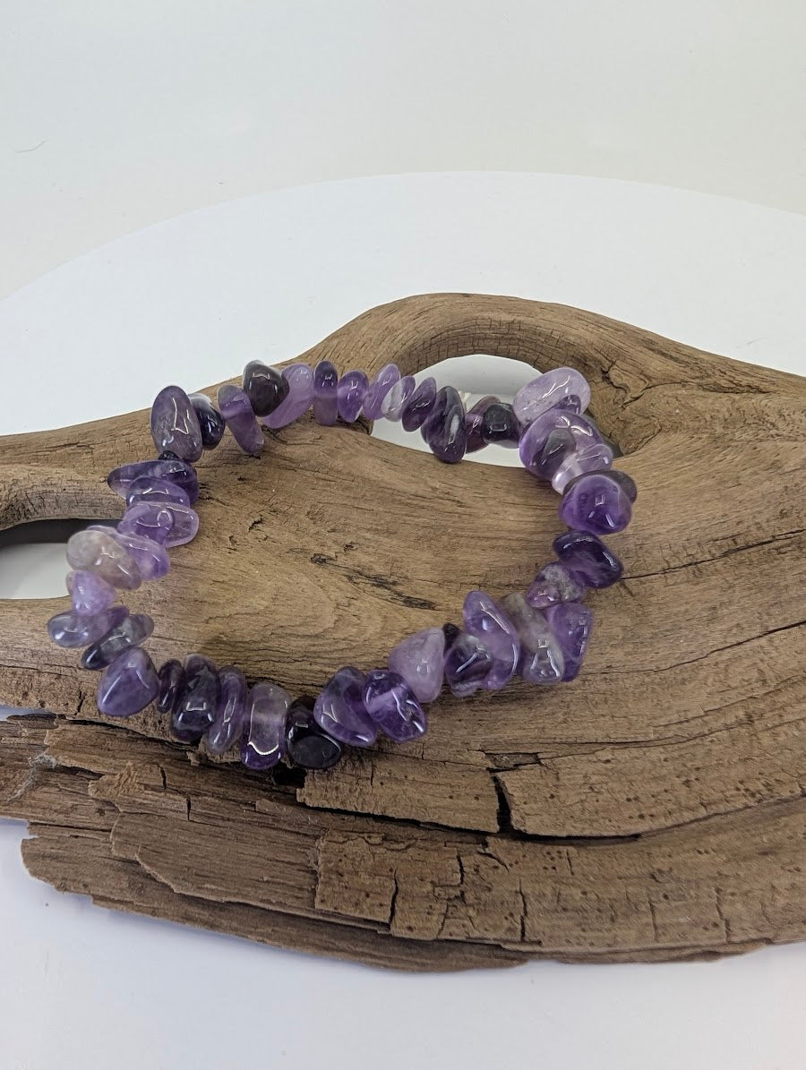 Natural Amethyst chip bracelet from Brazil displayed on driftwood showing deep purple tumbled stones.