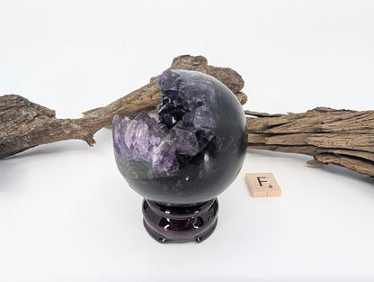 Angled view showing contrast between black basalt and purple crystal (Specimen F).