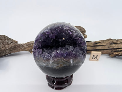 Exact-piece Uruguayan Amethyst Pac-Man sphere (Specimen M). Polished basalt matrix with enclosed cave-like violet vug.
