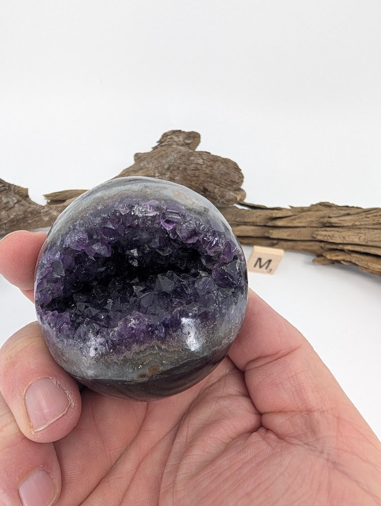 Hand-held view of cave-style Amethyst sphere Specimen M.