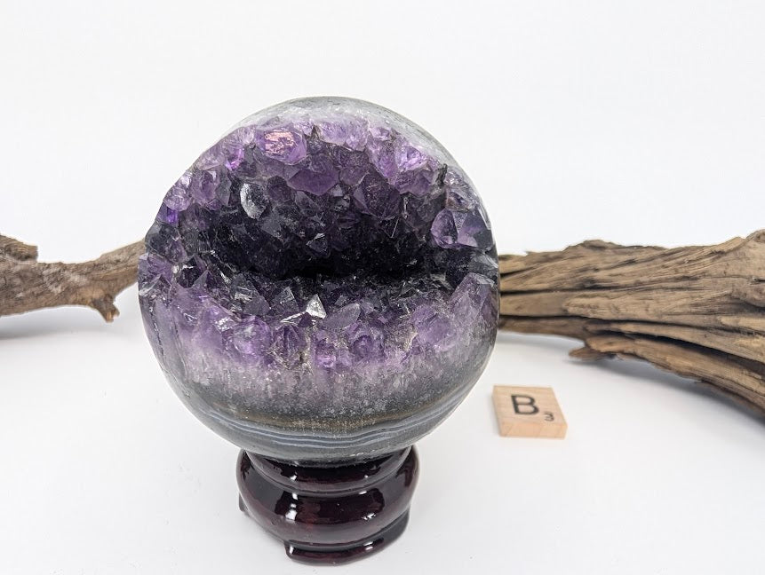 Exact-piece Uruguayan Amethyst Pac-Man sphere (Specimen B). Polished basalt matrix with wide smiling crystal vug