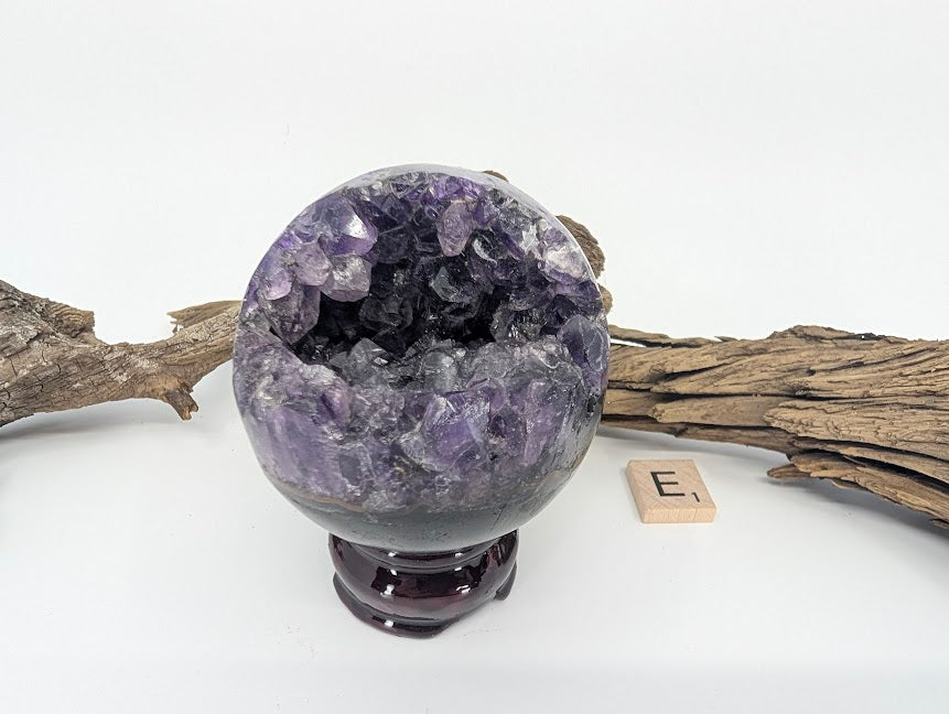 Exact-piece Uruguayan Amethyst Pac-Man sphere (Specimen E). Polished basalt matrix with voluminous rugged crystal mouth.