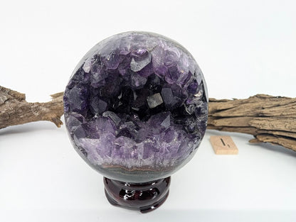 Exact-piece Uruguayan Amethyst Pac-Man sphere (Specimen I). Polished basalt matrix with jagged toothy crystal opening.