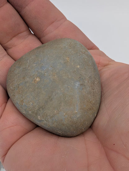 Angelite palm stone in hand showing natural light-blue color and smooth matte polish