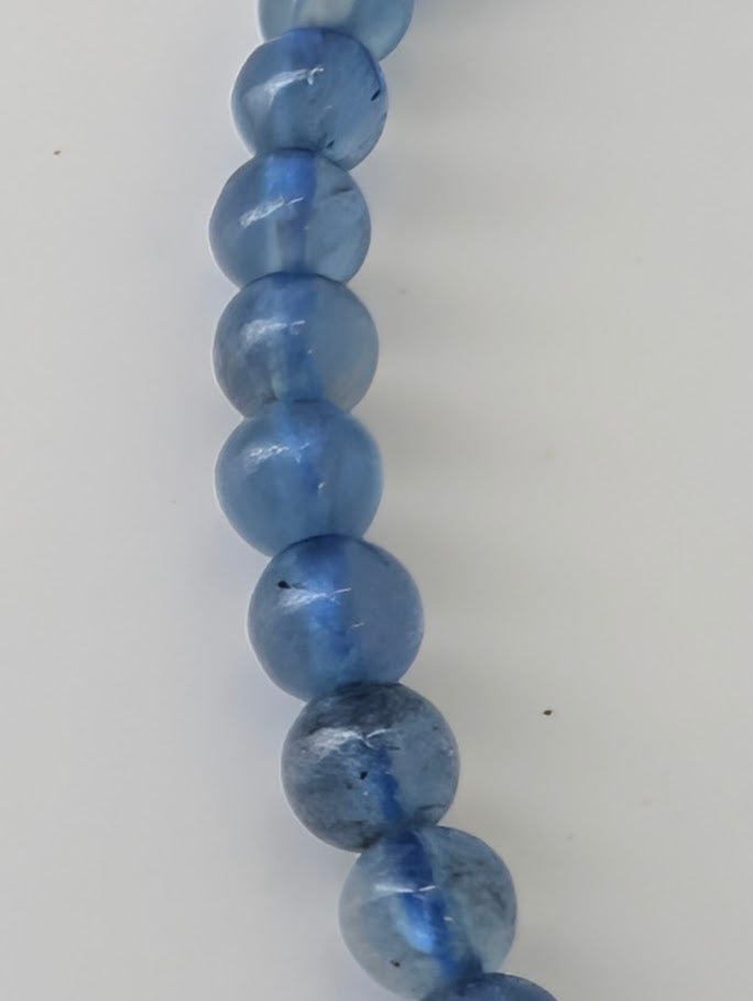 Detailed view of 4mm Aquamarine beads showing clarity and natural veining