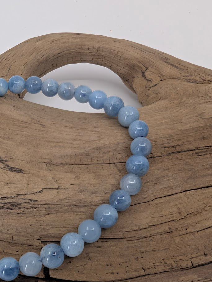 Close-up of 5mm aquamarine beads showing light blue color and polish