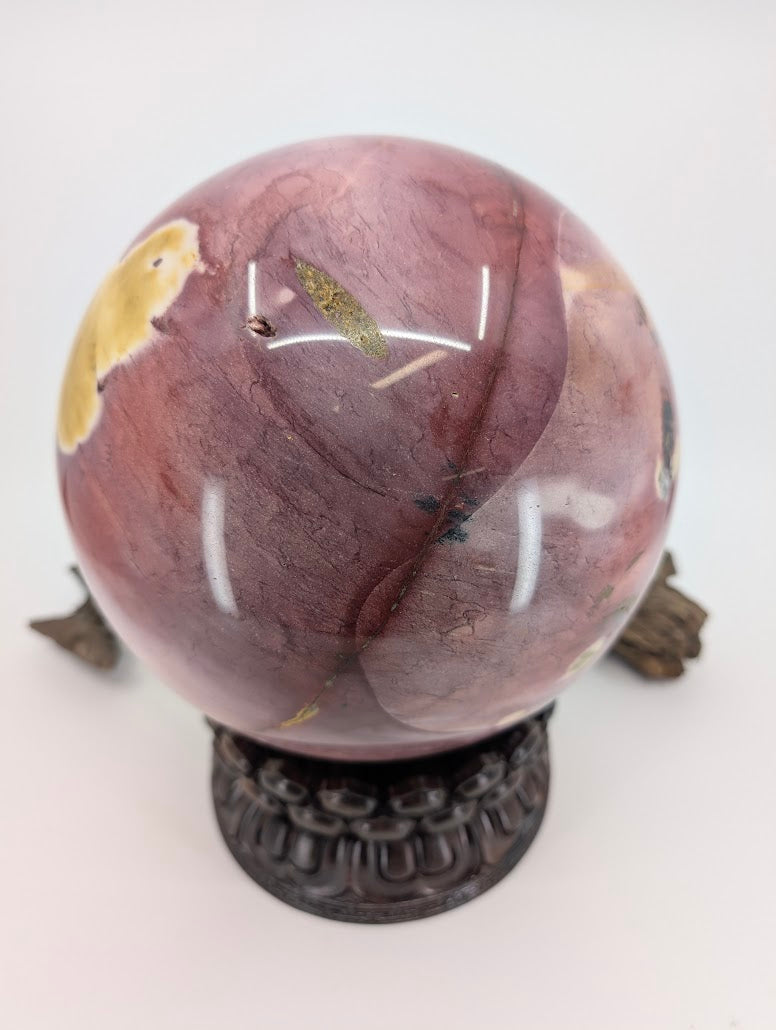 Side profile of an Australian Jasper sphere showing deep burgundy and lavender mineral banding.