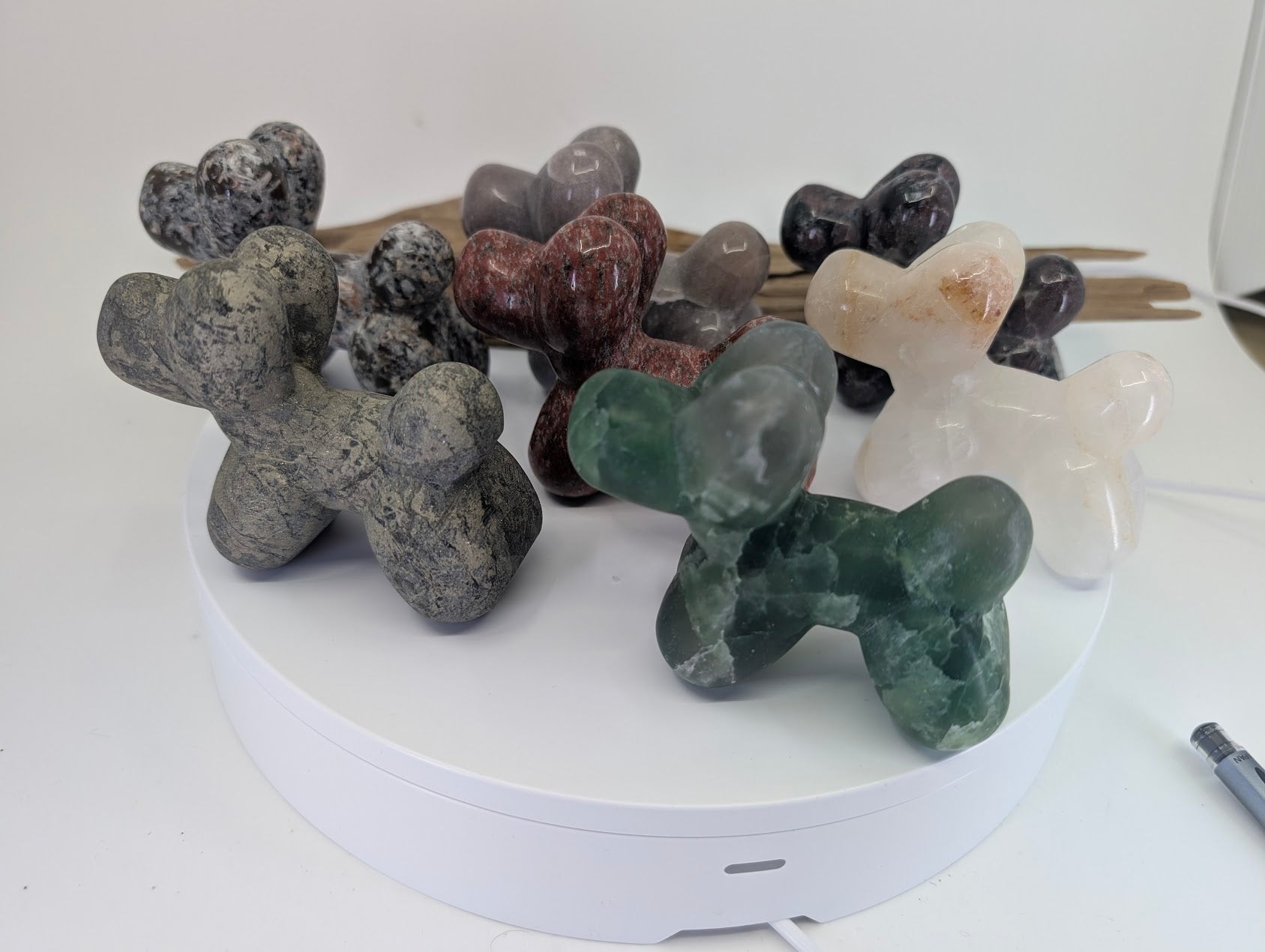 A diverse collection of hand-carved mineral balloon dogs in various stones for collector selection.