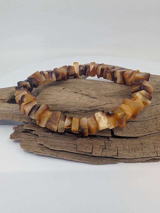 Baltic amber bracelet with 8mm+ polished chips displayed on driftwood
