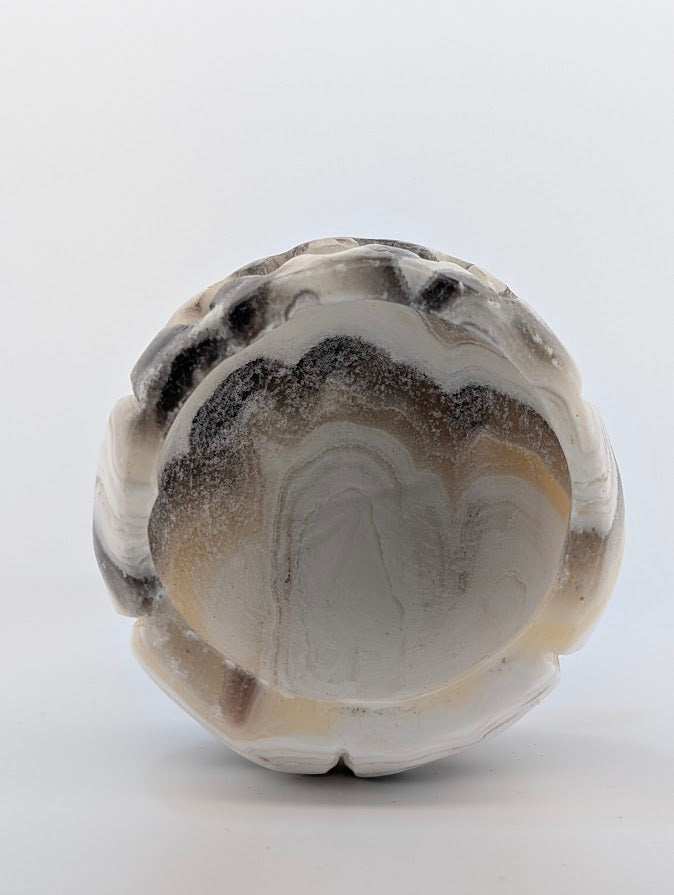 Banded calcite pumpkin carving – bottom view showing natural banding
