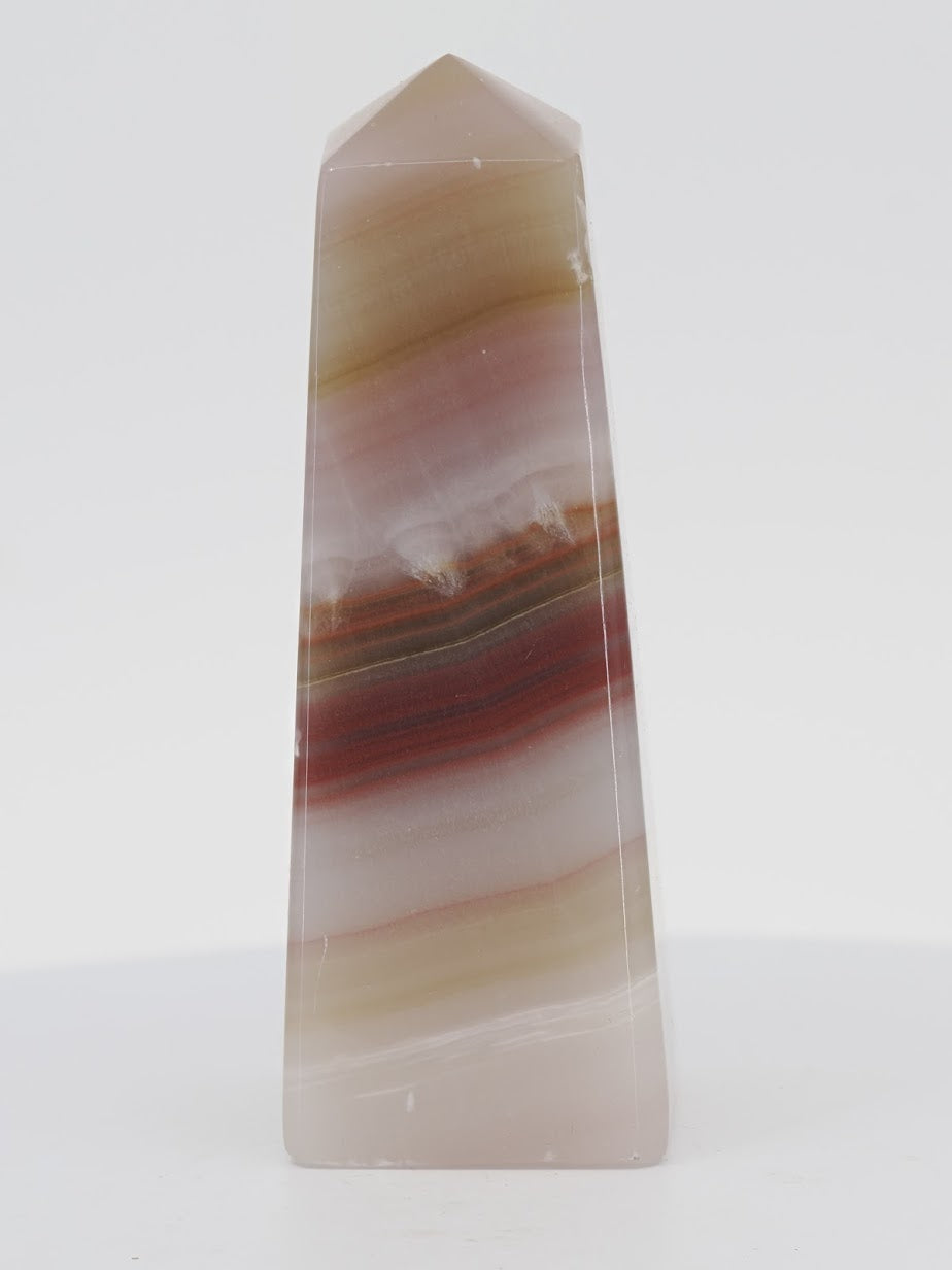Polished Banded Onyx tower from Pakistan featuring translucent champagne layers and deep rust-red mineral bands.