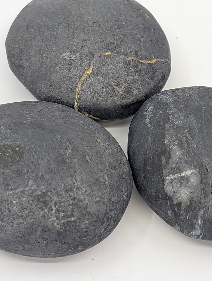Bitumen palm stones with natural variation and slight golden fissure patterns