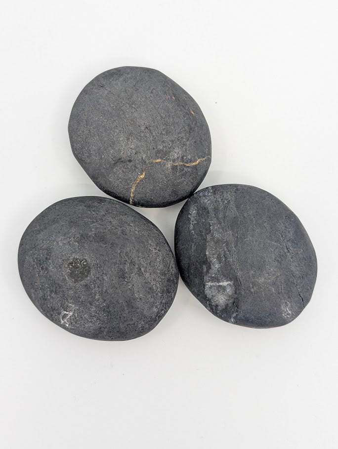 Close-up of bitumen palm stones showing natural texture and sheen