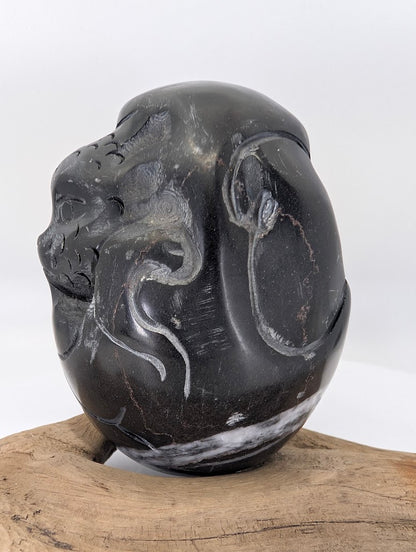 Side profile of a hand-carved Black Chu Stone Dragon from China, showing the high-relief scale detail.