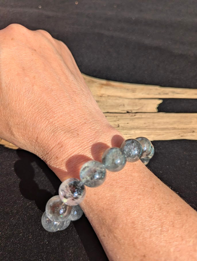 12mm AAA Grade Brazilian Girasol Black Devil Aquamarine beaded stretch bracelet worn on a wrist for scale.