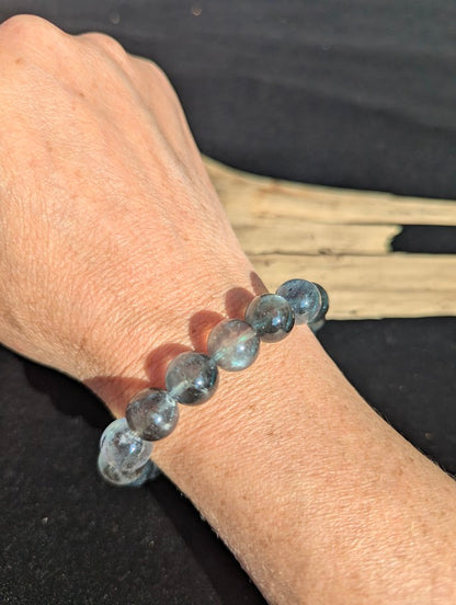 13mm AAA Grade Brazilian Girasol Black Devil Aquamarine beaded stretch bracelet worn on a wrist.