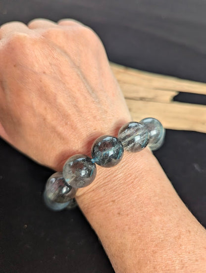 17mm statement AAA Grade Brazilian Girasol Black Devil Aquamarine beaded stretch bracelet worn on a wrist showing substantial collector presence.