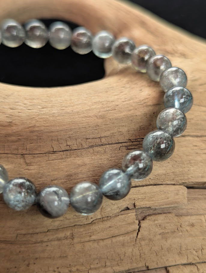 Macro close-up of 7mm Brazilian Black Devil Aquamarine beads highlighting the natural dark biotite inclusions and vitreous lustre.