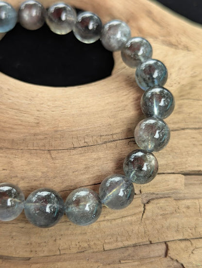 Macro view of 9mm Black Devil Aquamarine beads showing contrasting black mica structures suspended in translucent blue-grey beryl.