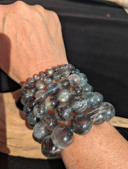 Complete stack of intuitively selected AAA Grade Brazilian Black Devil Aquamarine beaded bracelets worn together on a wrist demonstrating graduated bead sizes.