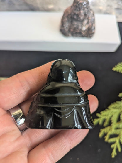 Back view of a Black Obsidian Laughing Buddha carving showing the uniform opaque black color and flawless polished surface.