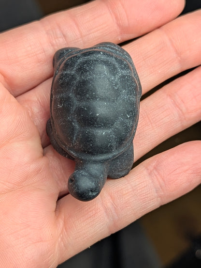 Alt Text: Top-down view of a hand-carved Black Obsidian crystal tortoise, showing detailed carapace shell patterning and head positioning.
