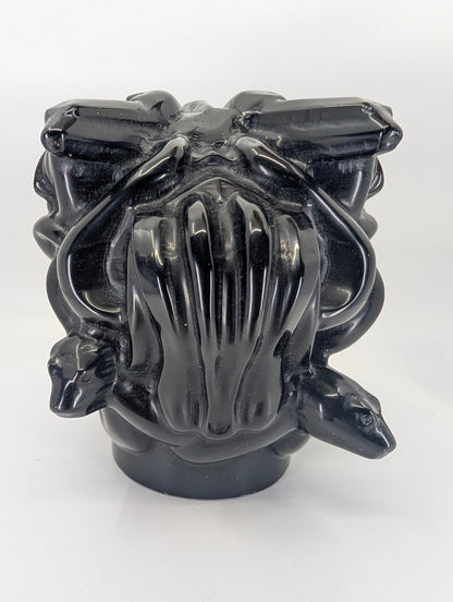 Back view highlighting carved snakes and flowing hair