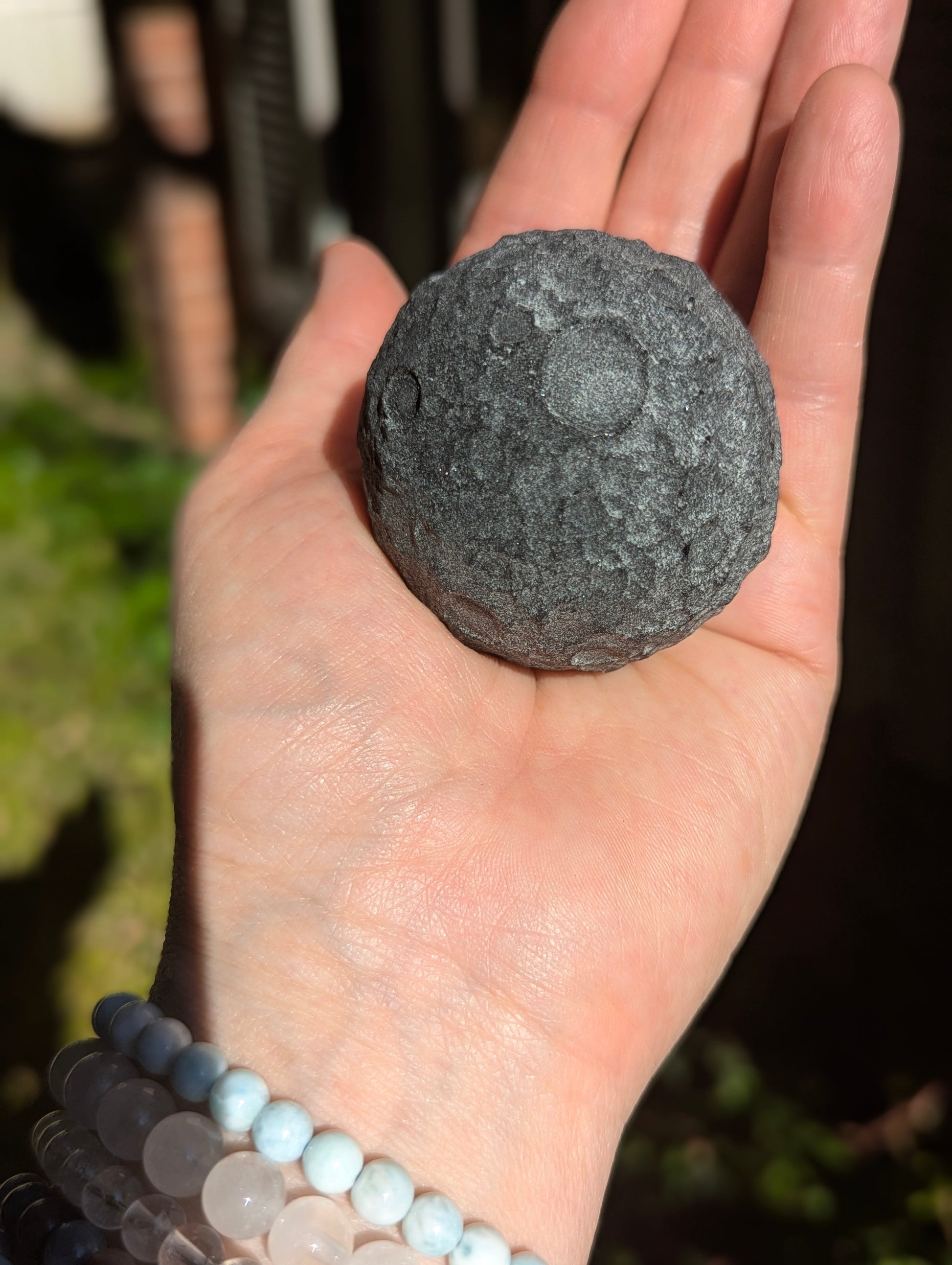 Black Obsidian 50mm Lunar carving held in hand for scale