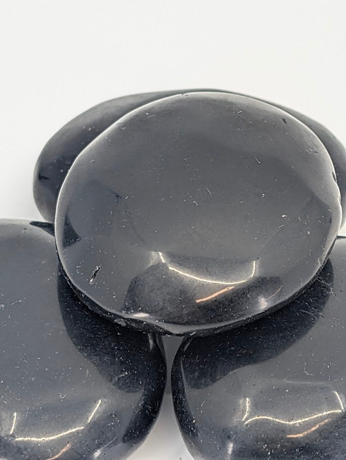Close-up of Black Obsidian Palm Stone reflective surface