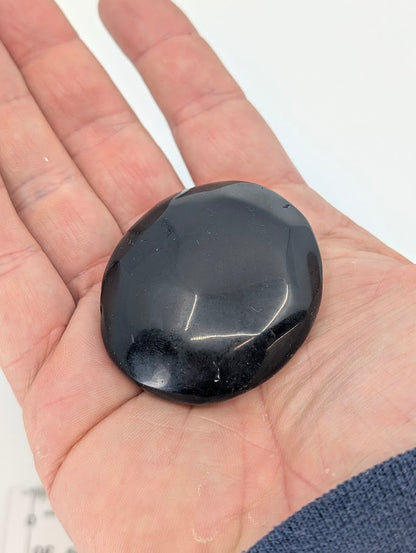 Black Obsidian Palm Stone in hand showing size