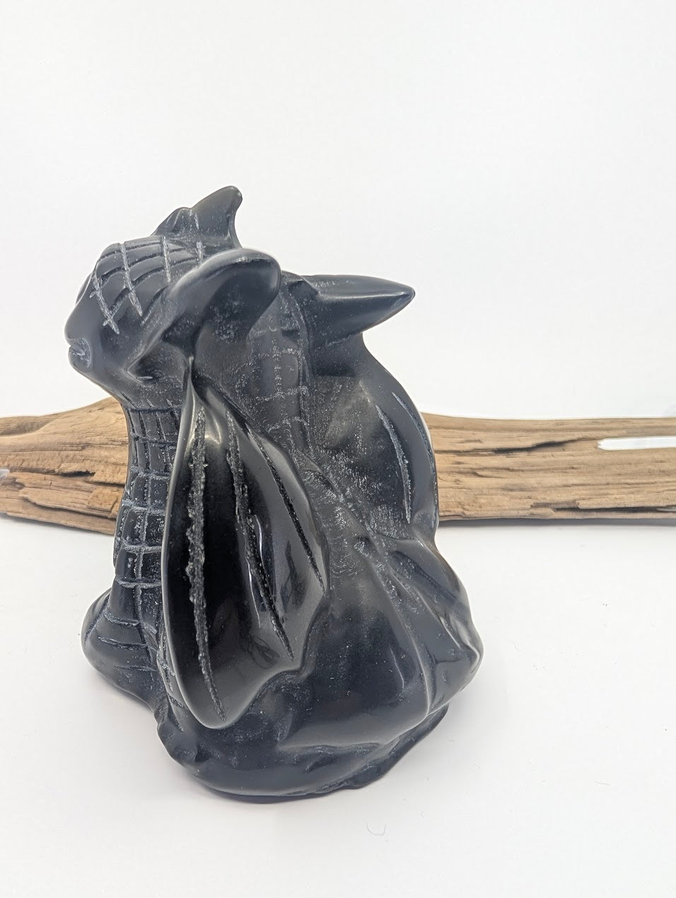 Rear view of the Black Obsidian dragon carving showing the high-gloss finish on the back and folded wings.