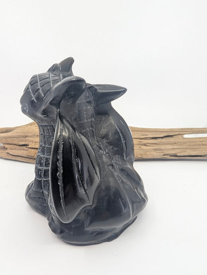 Rear view of the Black Obsidian dragon carving showing the high-gloss finish on the back and folded wings.