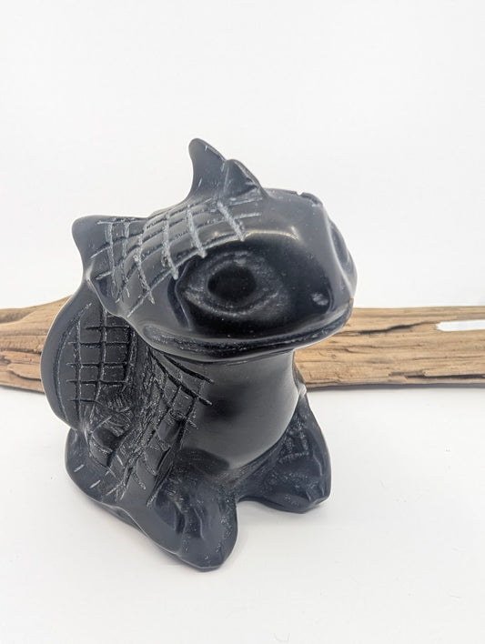 Front view of a Black Obsidian Toothless dragon carving showing matte-etched scale details on the head and wings.
