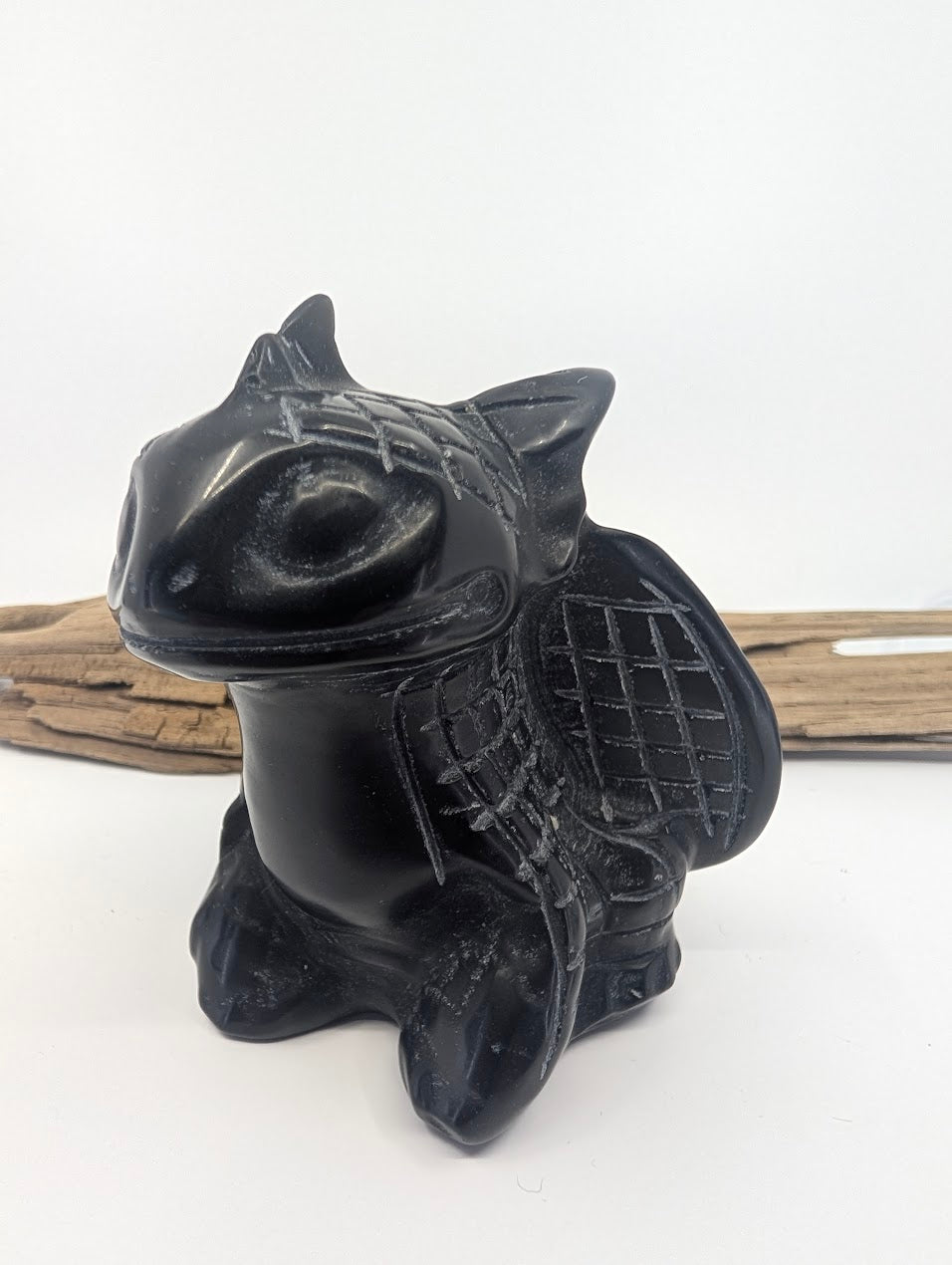 Side profile of a polished Black Obsidian dragon figurine highlighting the vitreous lustre and wing structure.