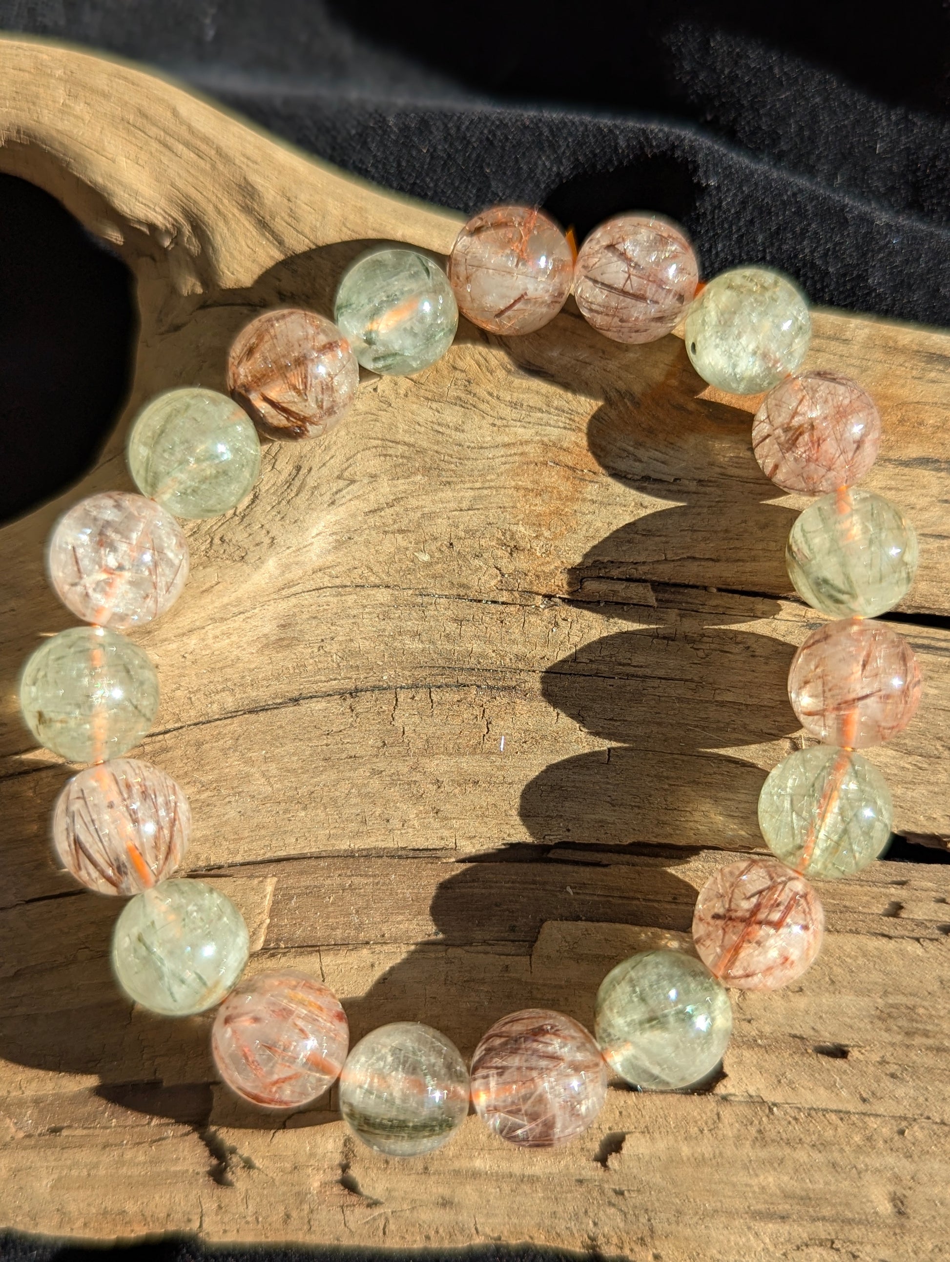 A 10mm bead stretch bracelet of premium black and red rutilated quartz from Brazil showing exceptional optical clarity and vivid colour zoning.