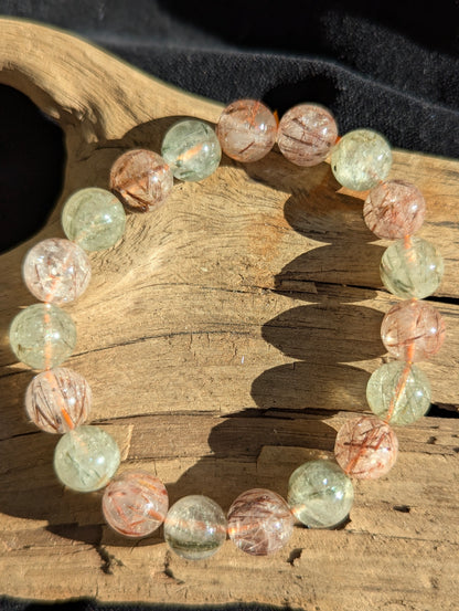 A 10mm bead stretch bracelet of premium black and red rutilated quartz from Brazil showing exceptional optical clarity and vivid colour zoning.