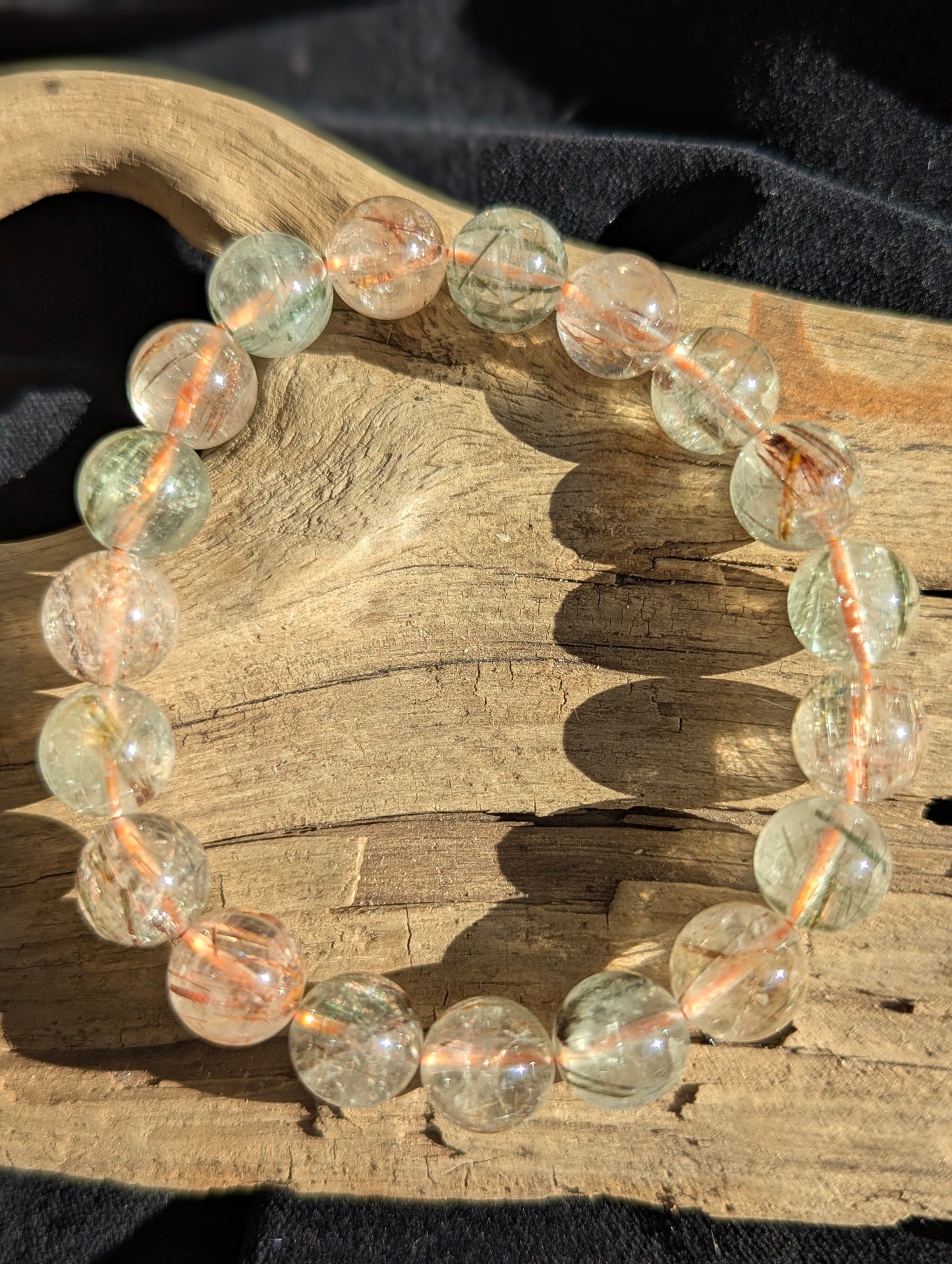 An 11mm bead stretch bracelet of premium Brazilian black and red rutilated quartz showing exceptional optical clarity and vivid colour zoning.