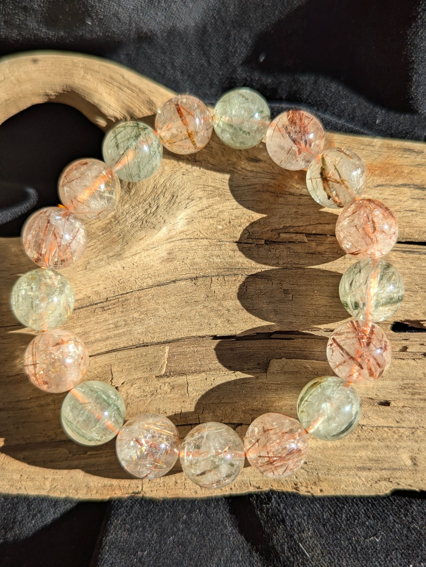 An oversized 13mm bead stretch bracelet featuring vivid copper and black rutile needle inclusions suspended within a flawless Brazilian transparent quartz matrix.