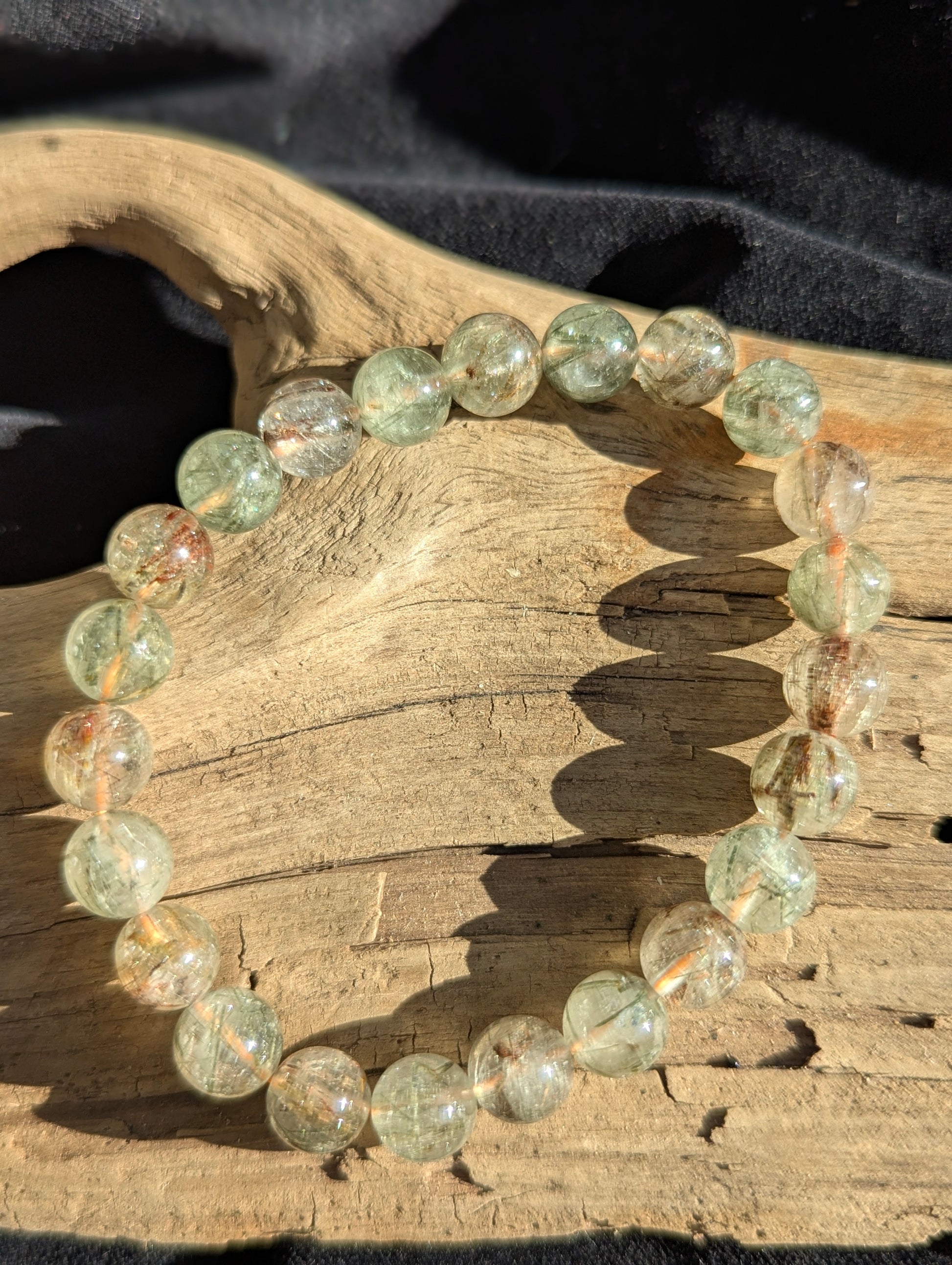 A 9mm bead stretch bracelet made of clear Brazilian macrocrystalline quartz heavily included with natural black and red rutile crystals.
